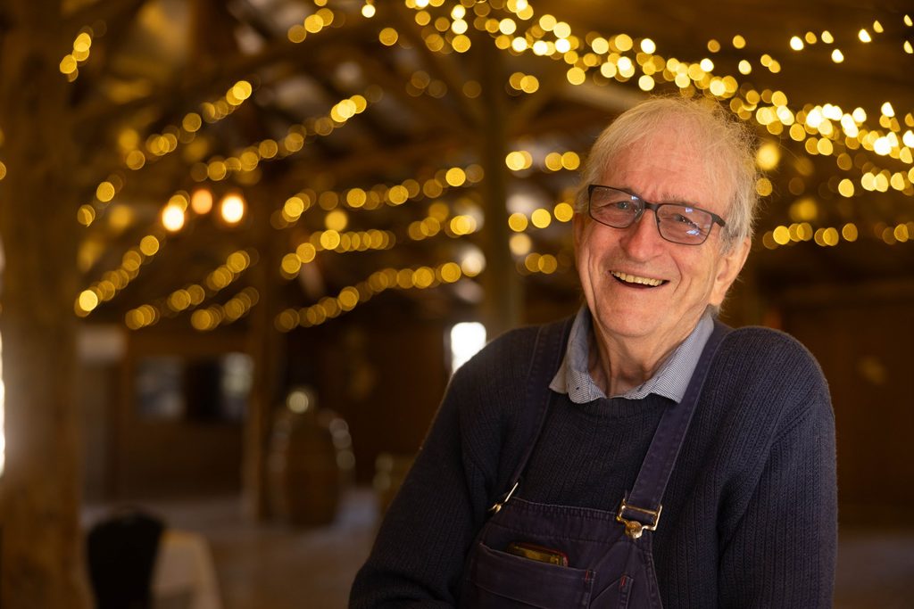 Smiling man beneath warm string lights