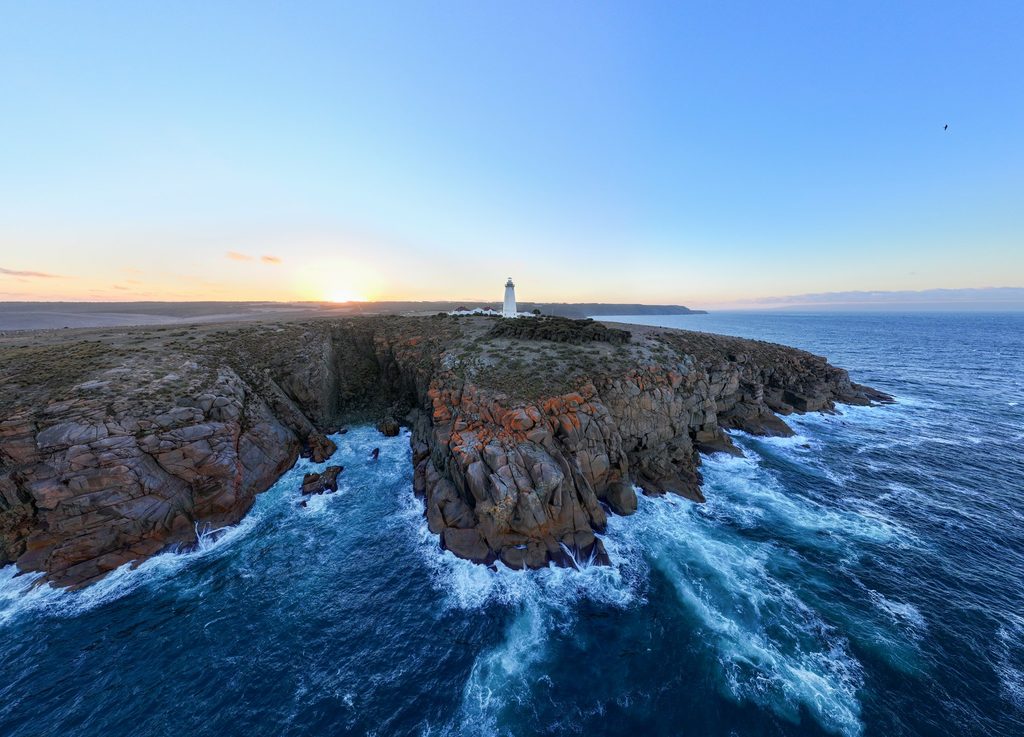 Lighthouse above a rugged coast and blue sea