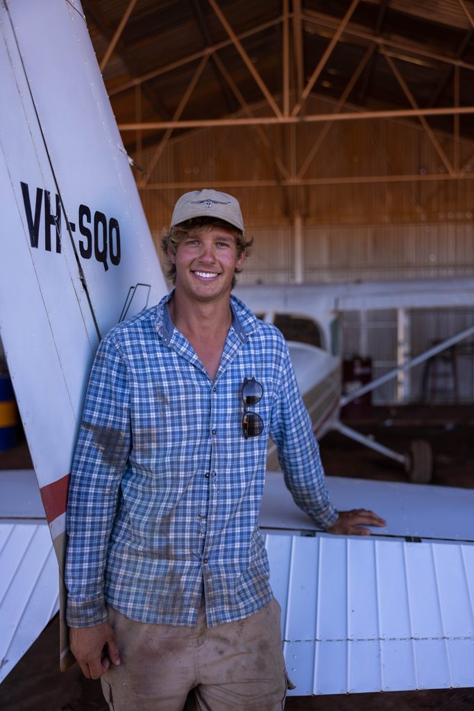 Man standing beside an aircraft in a hangar