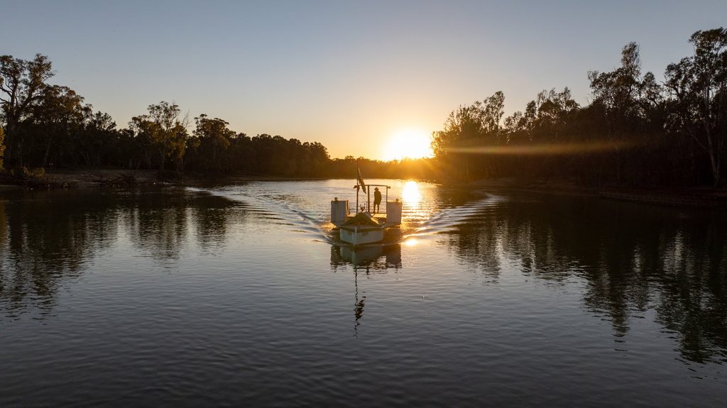 Small boat on a calm river at sunset